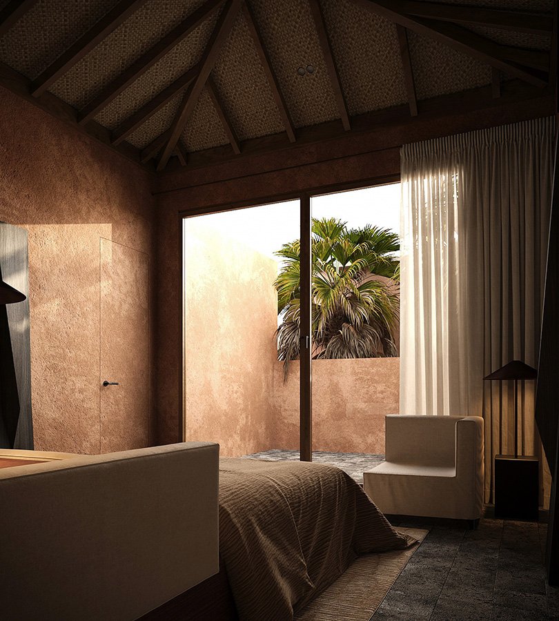 A bedroom with a large window showing a view of a palm tree outside. The room has a sloped ceiling with wood beams, a bed with brown bedding, and a white armchair near the window with cream curtains.