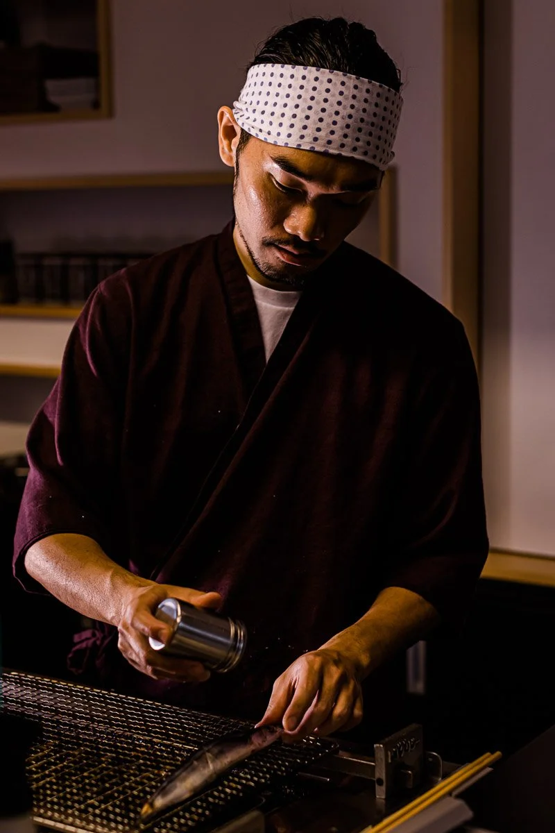 Ein Koch bereitet Sushi in einer Küche vor.