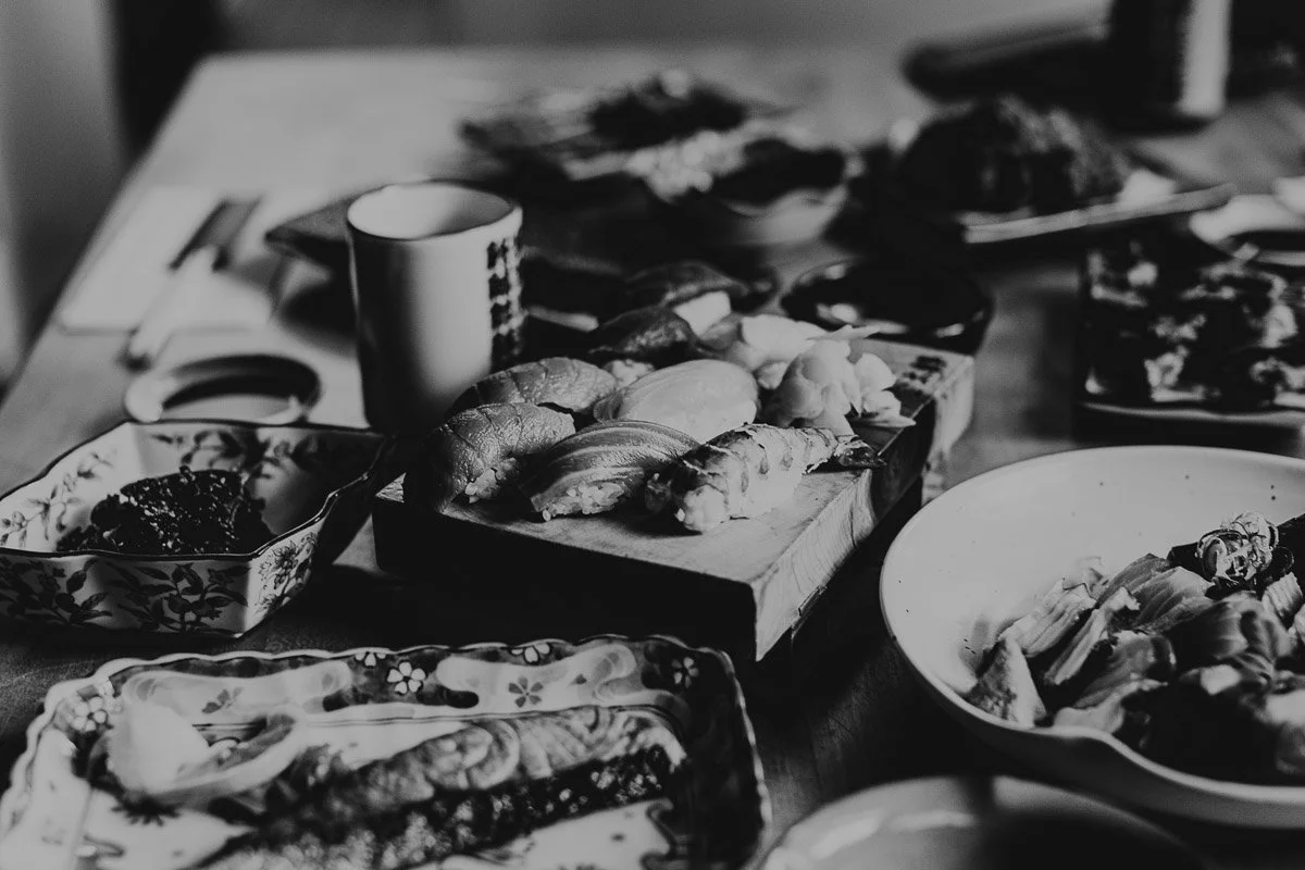 Ein Teller mit Sushi, verschiedene Saucen und andere japanische Speisen auf einem Esstisch.