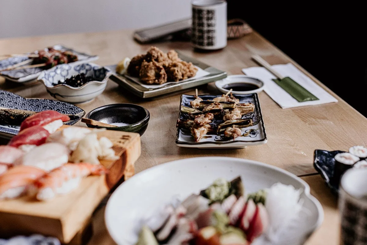 Verschiedene japanische Gerichte und Sushi auf einem Holztablett und in Schalen