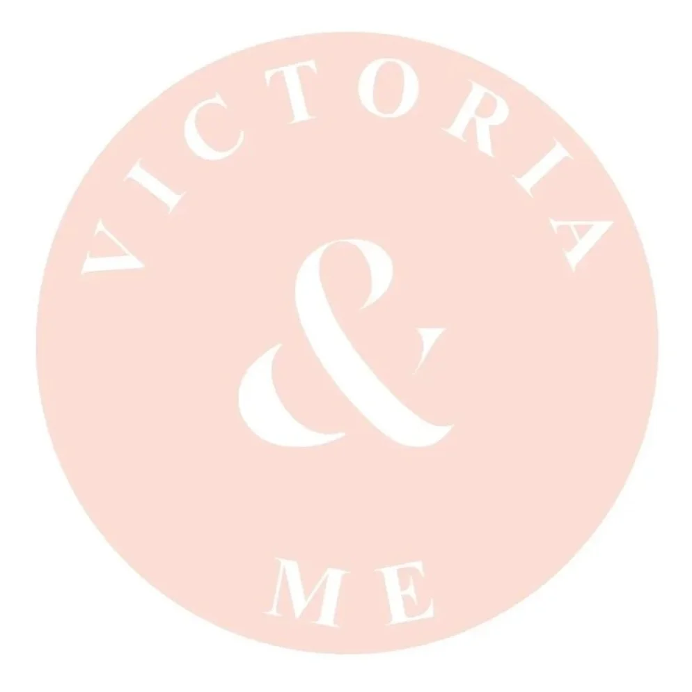 A circular logo with a pink background that says 'VICTORIA & ME' around the edge in white text.