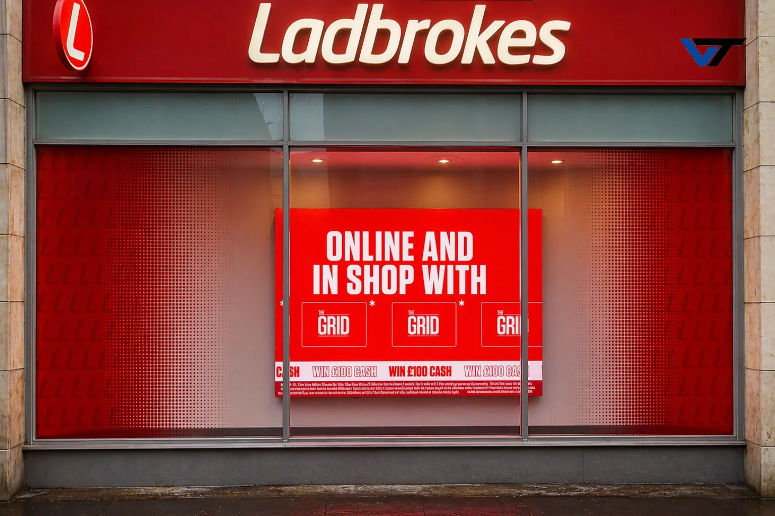 Storefront of Ladbrokes with a large red promotional poster advertising online and in-shop betting, featuring the logo 'The Grid' and offering a chance to win £100 cash.
