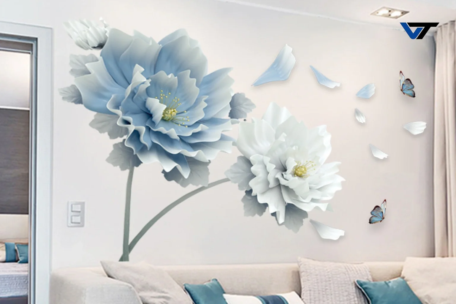Decorative wall decal featuring large 3D white and light blue flowers and small blue butterflies above a beige couch with blue and white cushions in a living room.