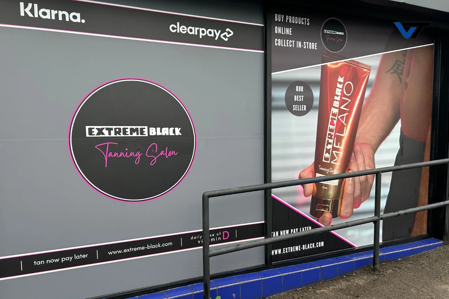 Advertisement for Extreme Black Tanning Salon with a large photo of a person holding a tube of tanning butter labeled Extreme Black MAFLAC, and the salon's logo and website.