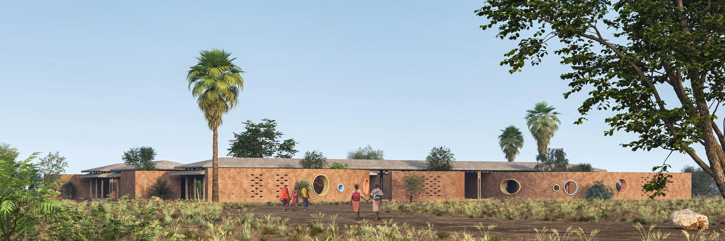 A modern, single-story brick building with circular windows, surrounded by palm trees and greenery, with four people walking towards it in a field.