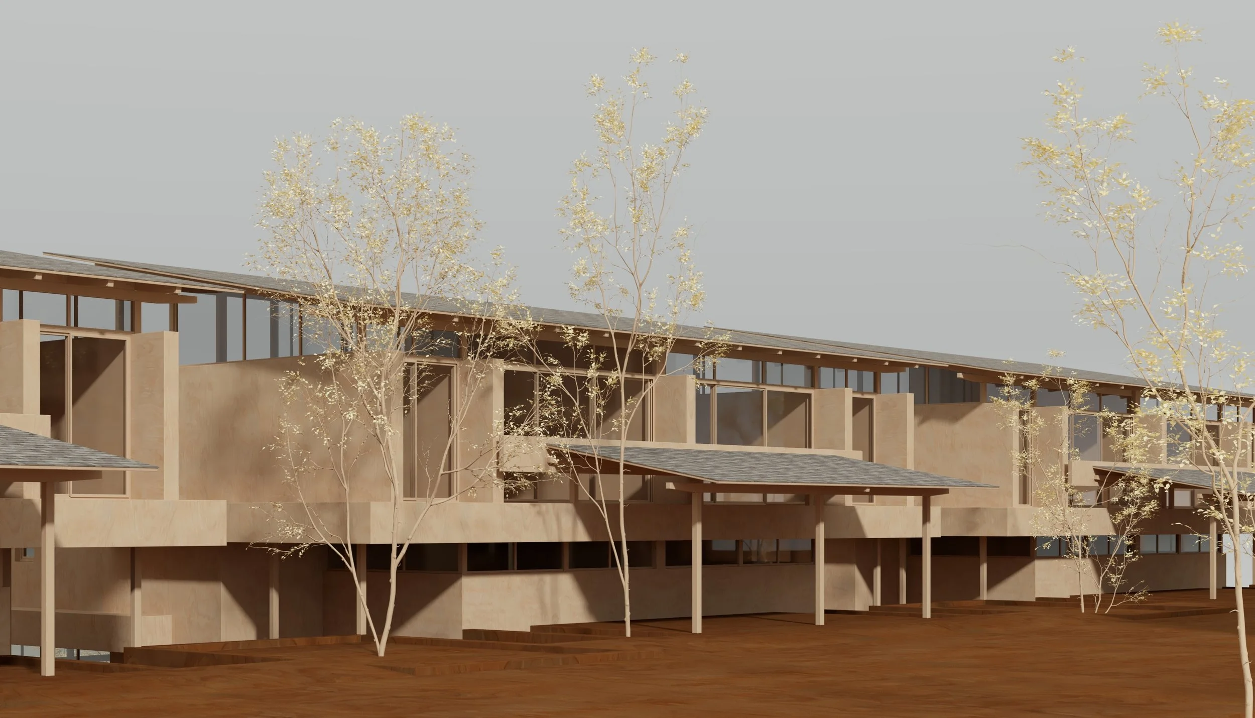 A modern multi-story building with large windows, beige exterior walls, and balconies. There are leafless trees in front and a clear sky in the background.