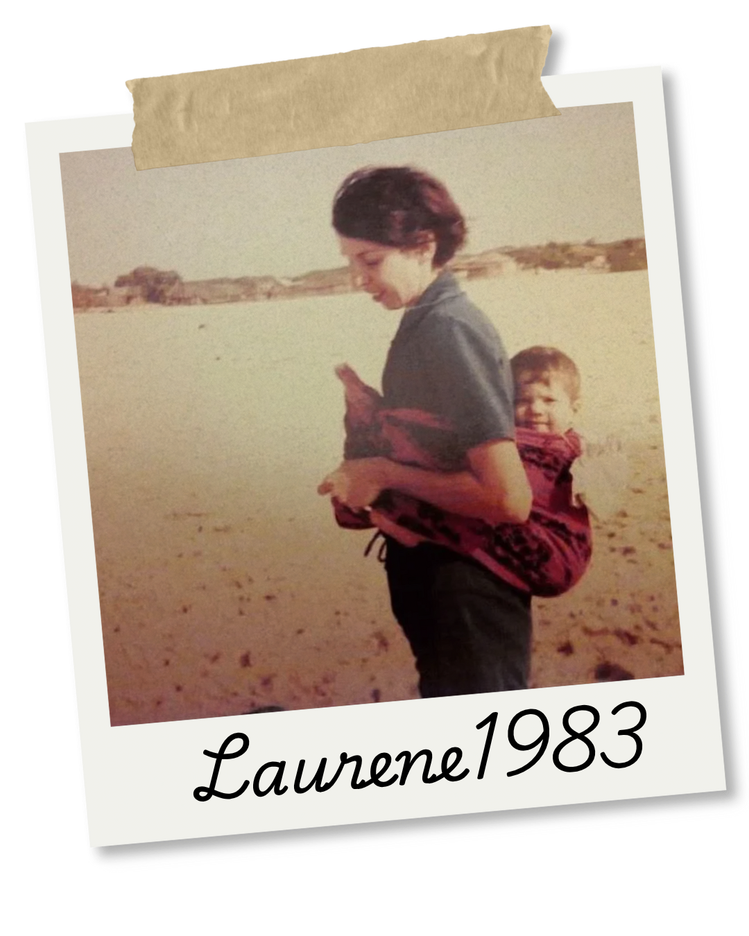 A woman carrying a young child on her back using a fabric wrap on a sandy beach with a distant land visible across the water, dated 1983, labeled with the name Laurene.