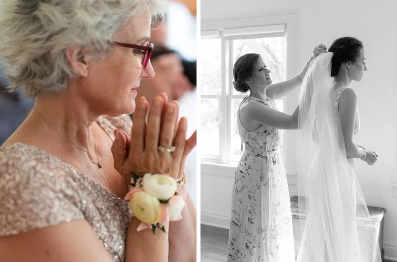 A woman with gray hair and glasses praying with her hands together, wearing a lace dress and a corsage, during a wedding ceremony. Another woman is helping a bride with her veil near a window, in a softly lit room.