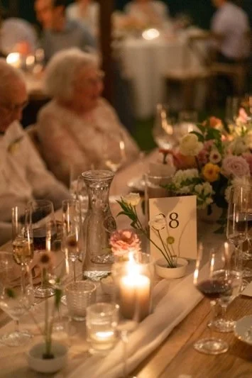 An elegant dinner table setup with floral arrangements, candles, and wine glasses at a formal event.