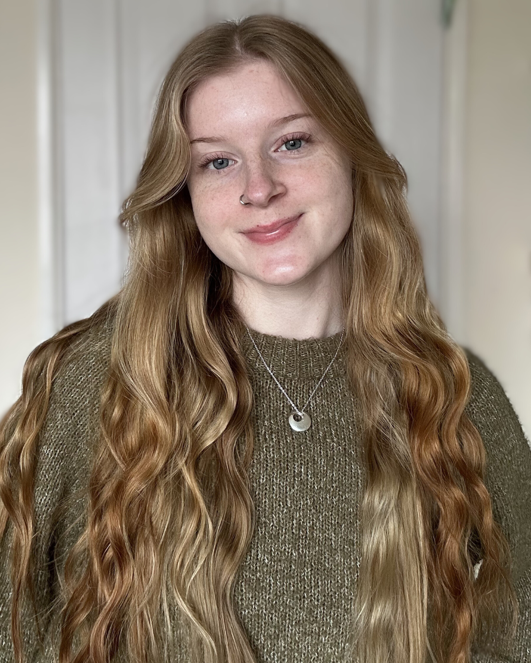 Hannah social media manager and founder of Cloverbloom Digital, smiling in a neutral indoor setting.