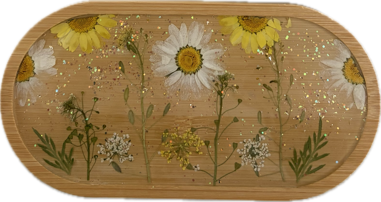 Resin flower wooden tray. Pressed yellow and white daisies and small white and yellow wildflowers with green stems and leaves on a wooden tray with glitter.