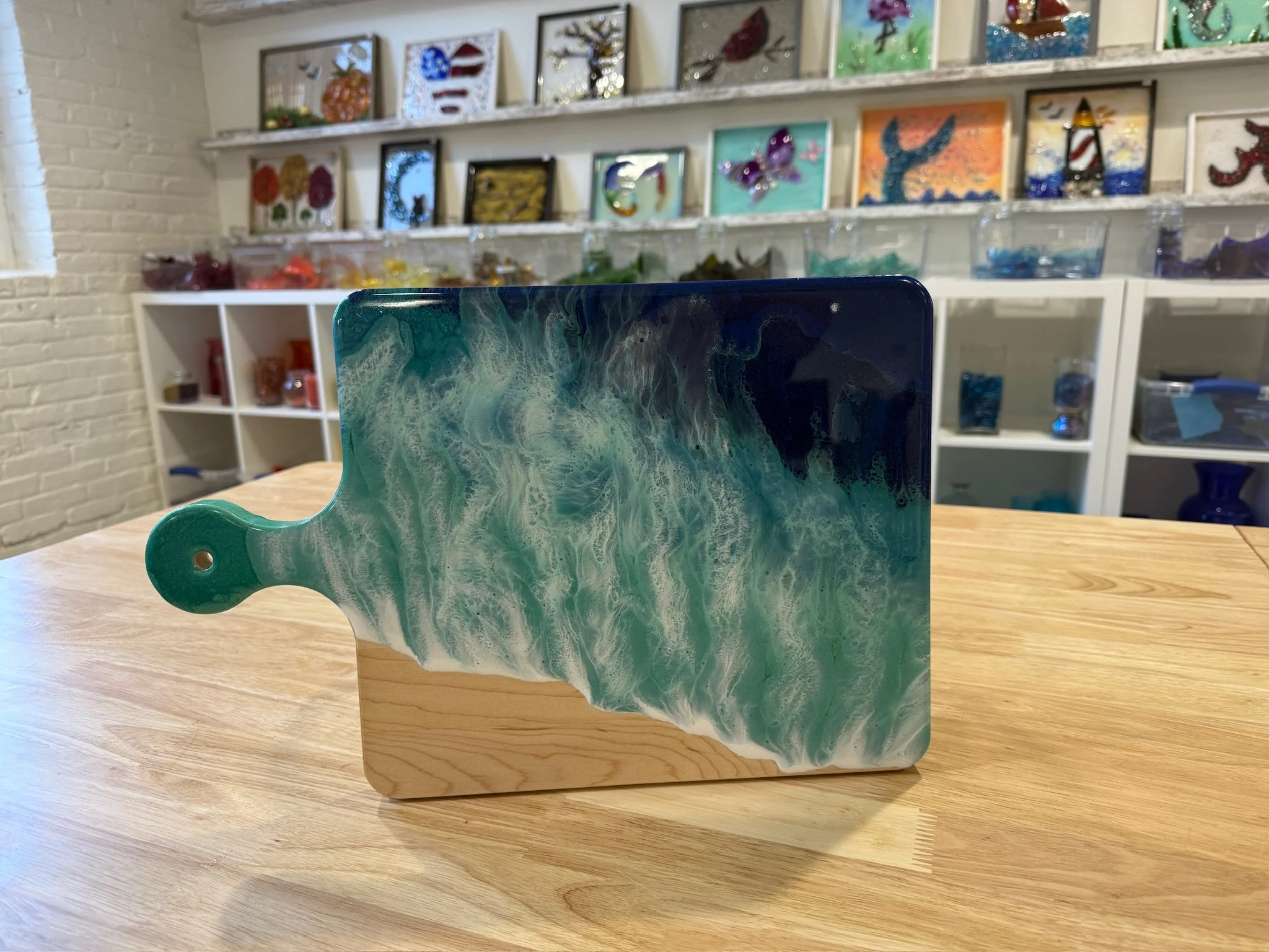 Large Wooden charcuterie board with resin ocean wave poured on it.