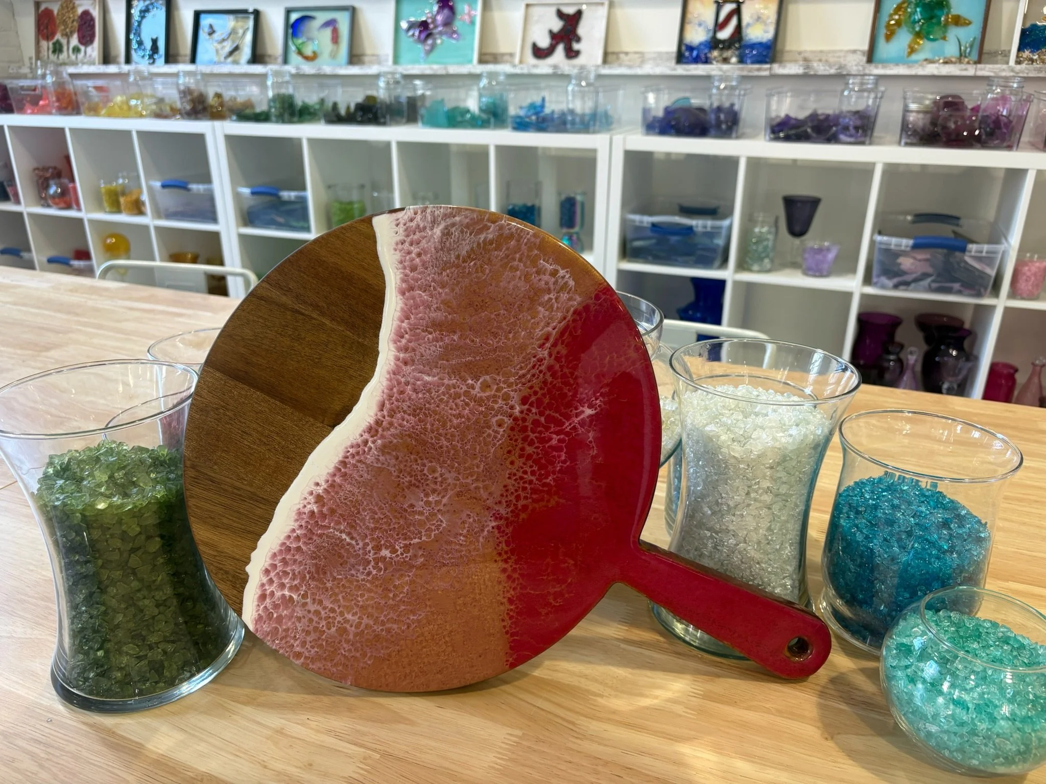 Round Wooden charcuterie board with resin ocean wave poured on it.