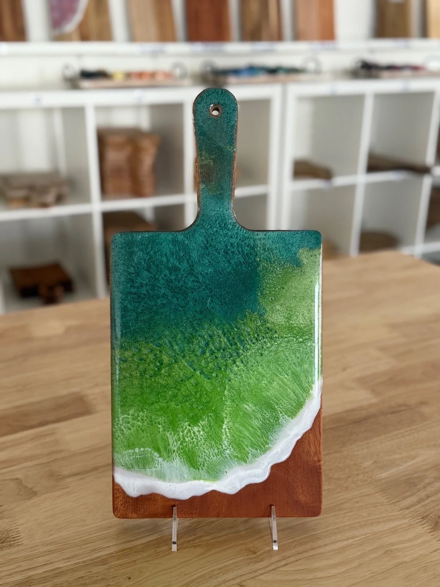 Wooden charcuterie board with resin ocean wave poured on it. 