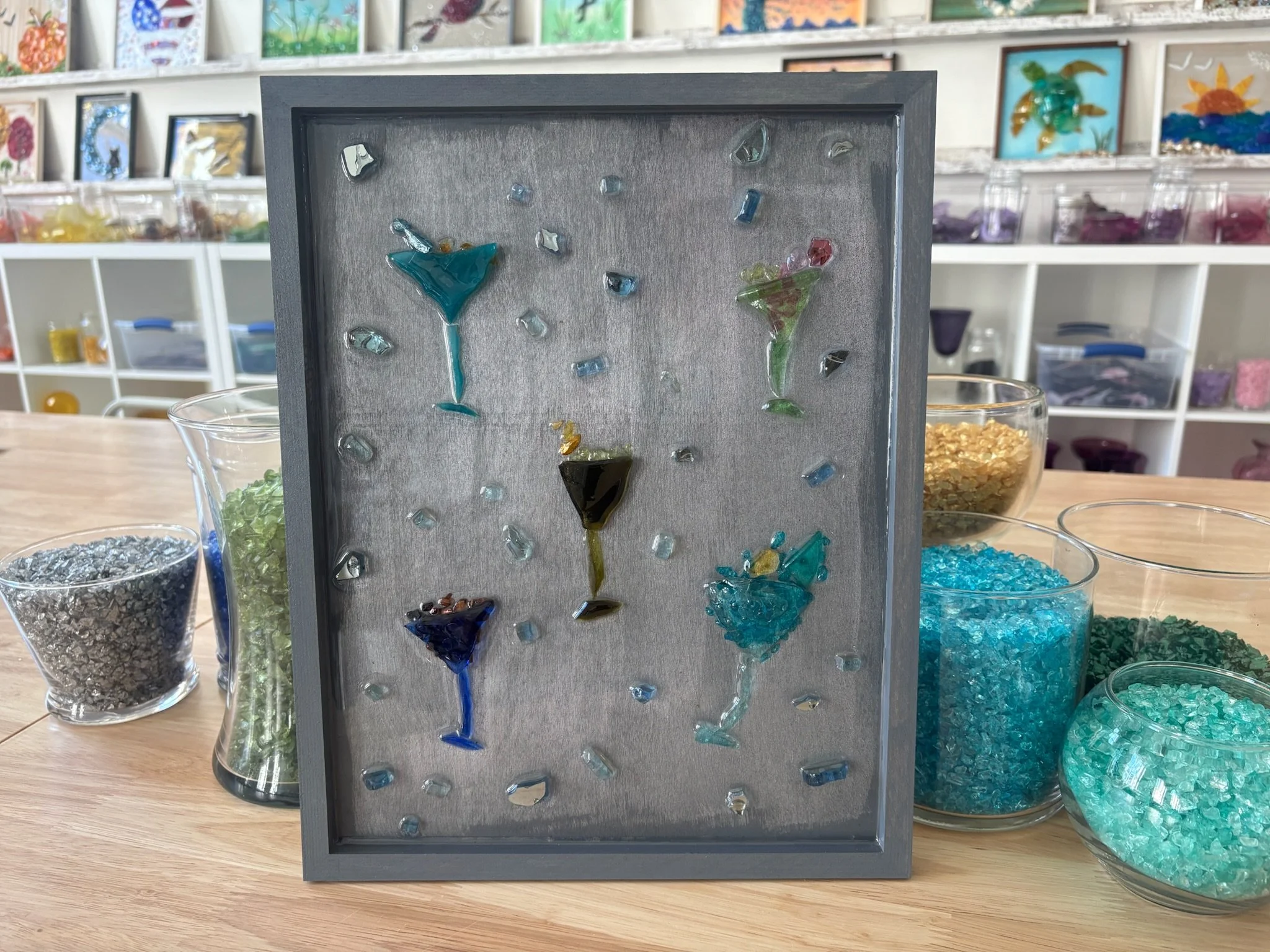 Resin Glass Art of various alcohol drinks in their glasses using cut and crushed glass in a painted frame. 