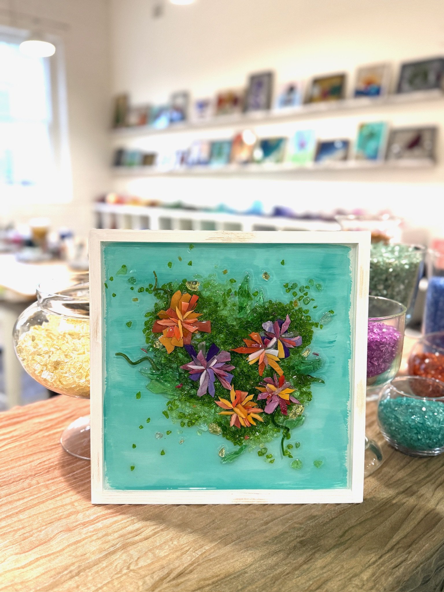 Resin Glass Art of a flowers using cut and crushed glass in a painted frame.