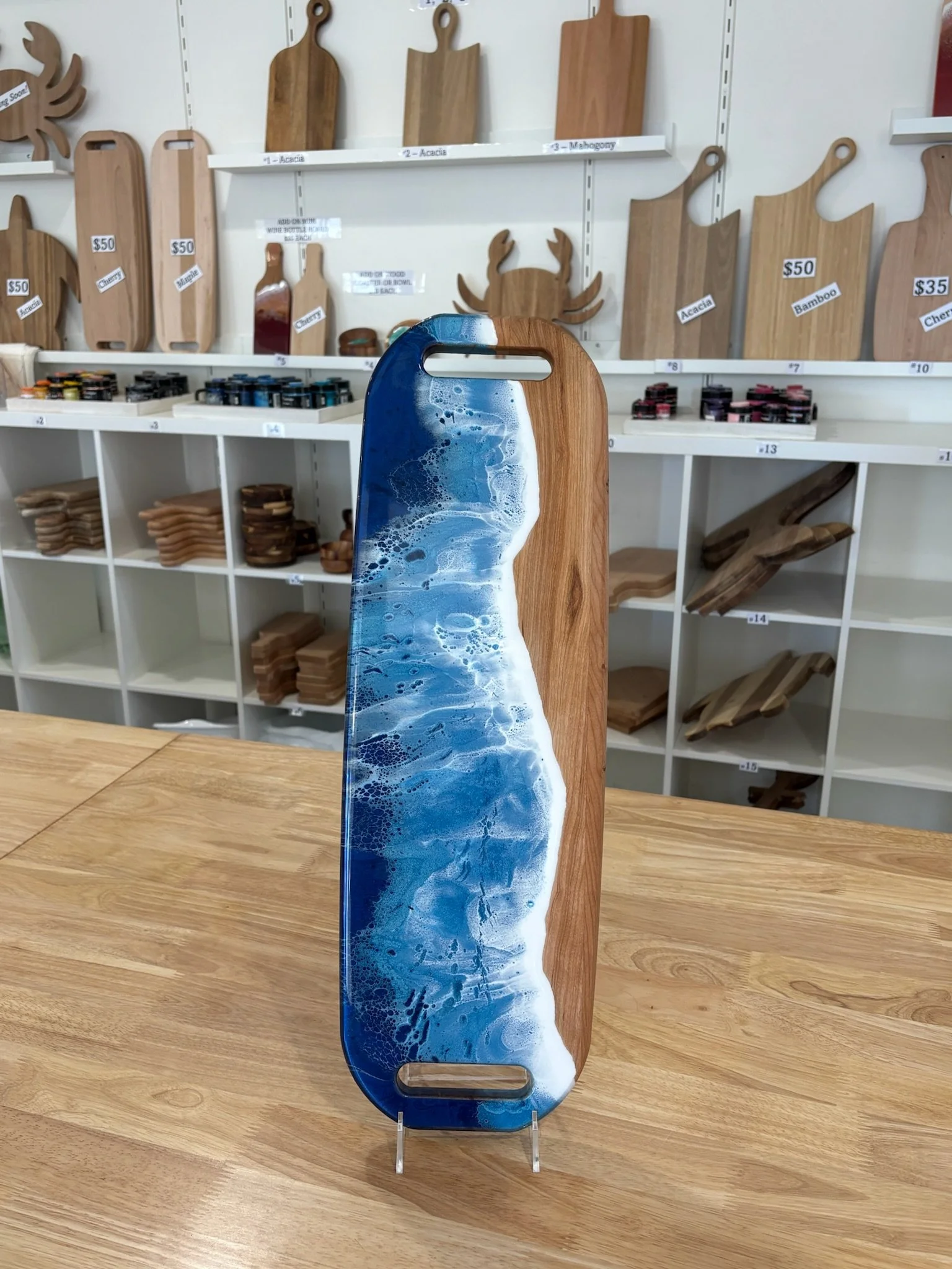 Large Wooden charcuterie board with resin ocean wave poured on it.