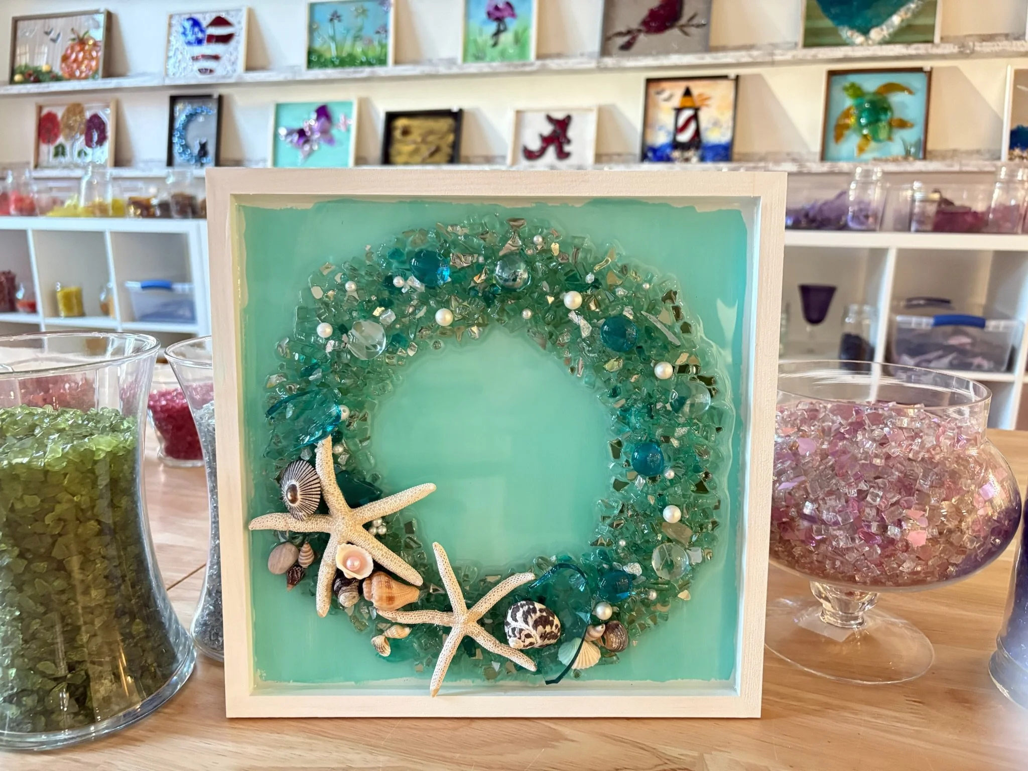 Resin Glass Art of an ocean themed wreath using cut and crushed glass in a painted frame.