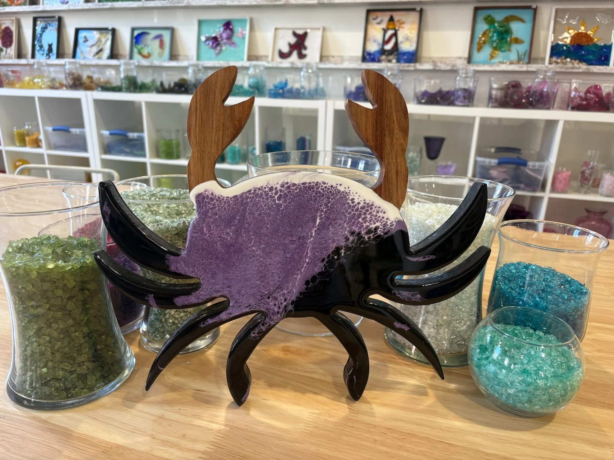 Wooden crab shaped charcuterie board with resin ocean wave poured on it using Baltimore Ravens colors (purple and black).