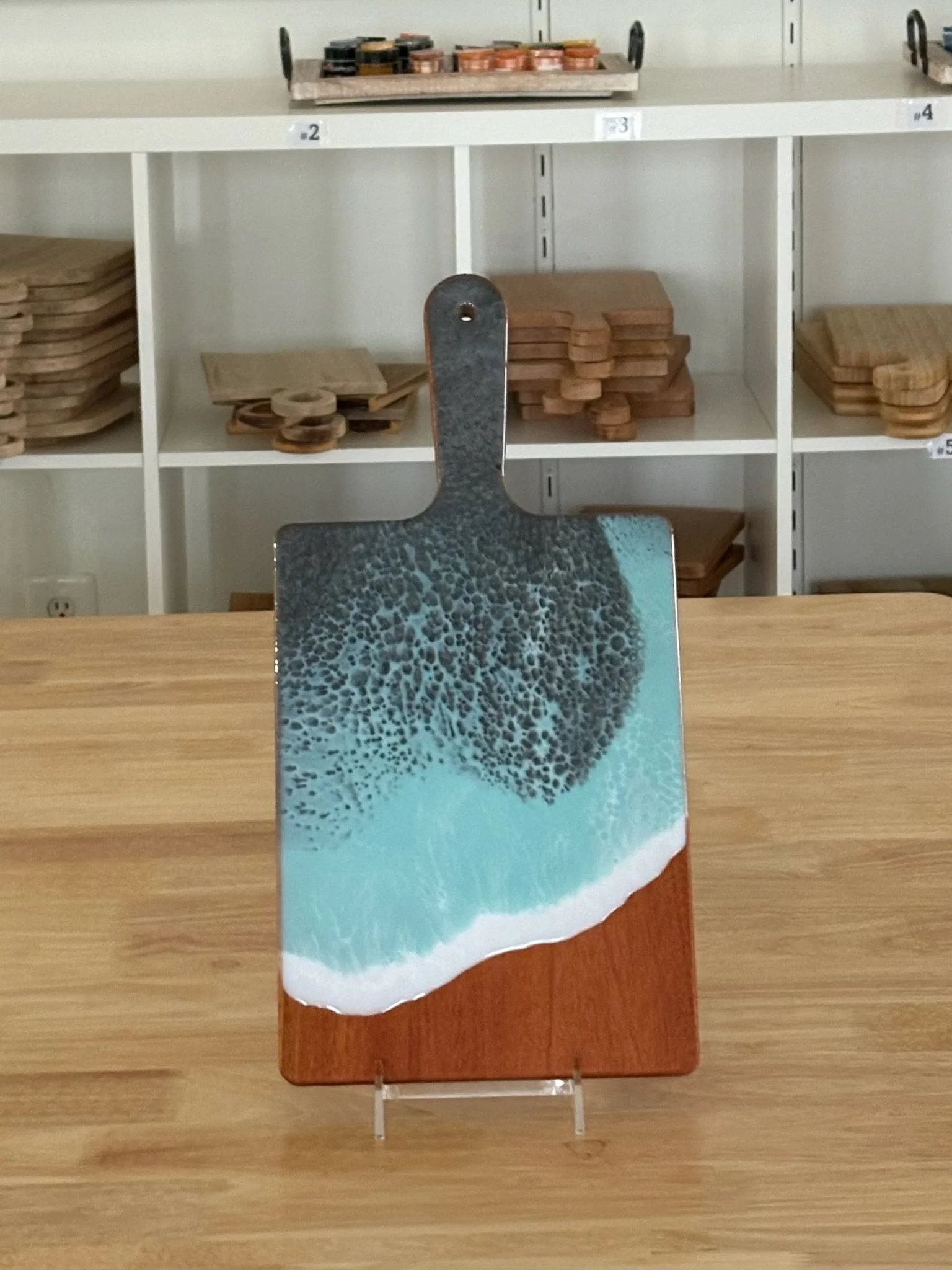 Wooden charcuterie board with resin ocean wave poured on it. 