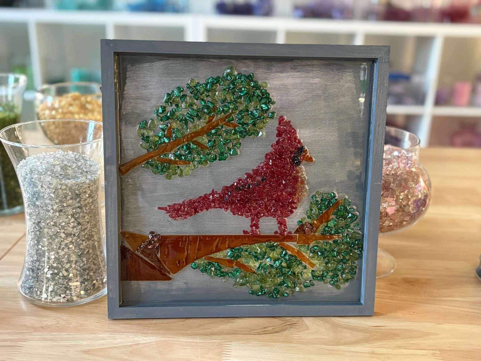 Resin Glass Art of a cardinal using cut and crushed glass in a painted frame.