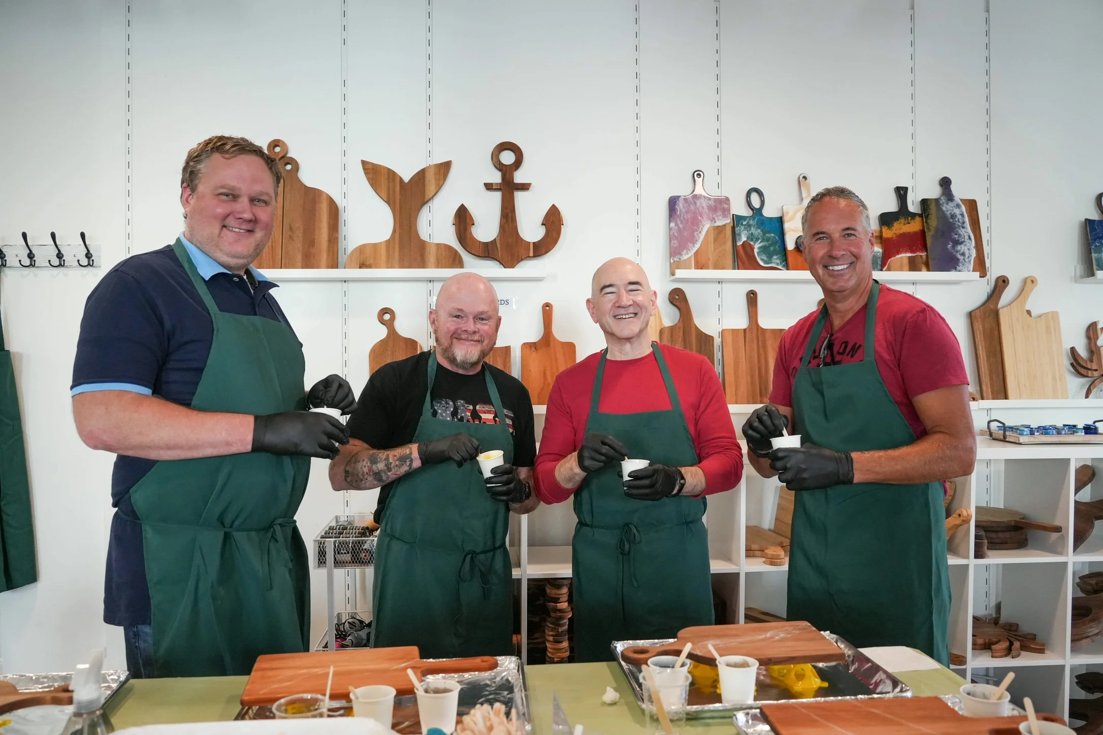Guys group mixing resin during wood charcuterie board resin DIY workshop - activity/event/private party