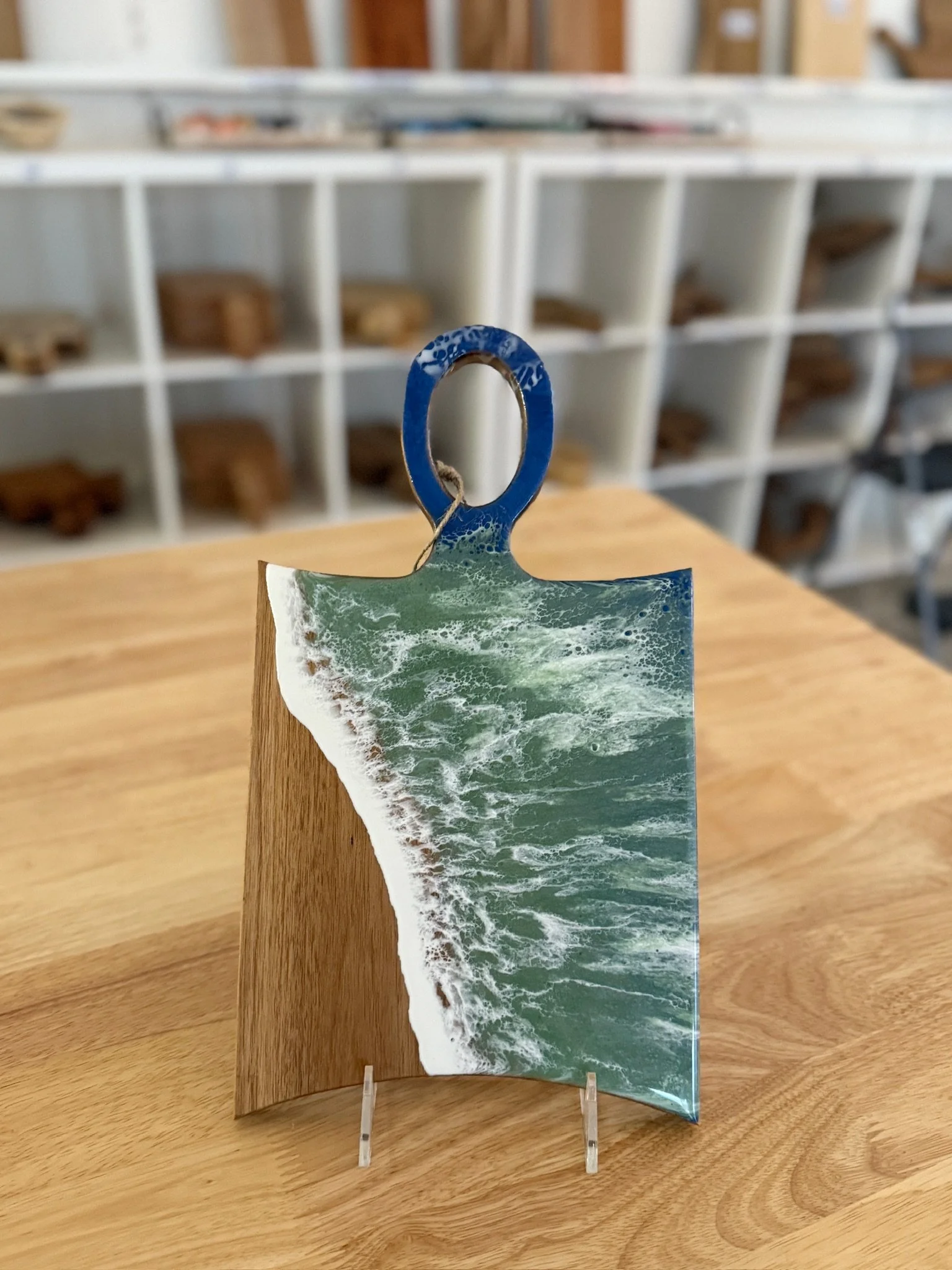 Wooden charcuterie board with resin ocean wave poured on it. 