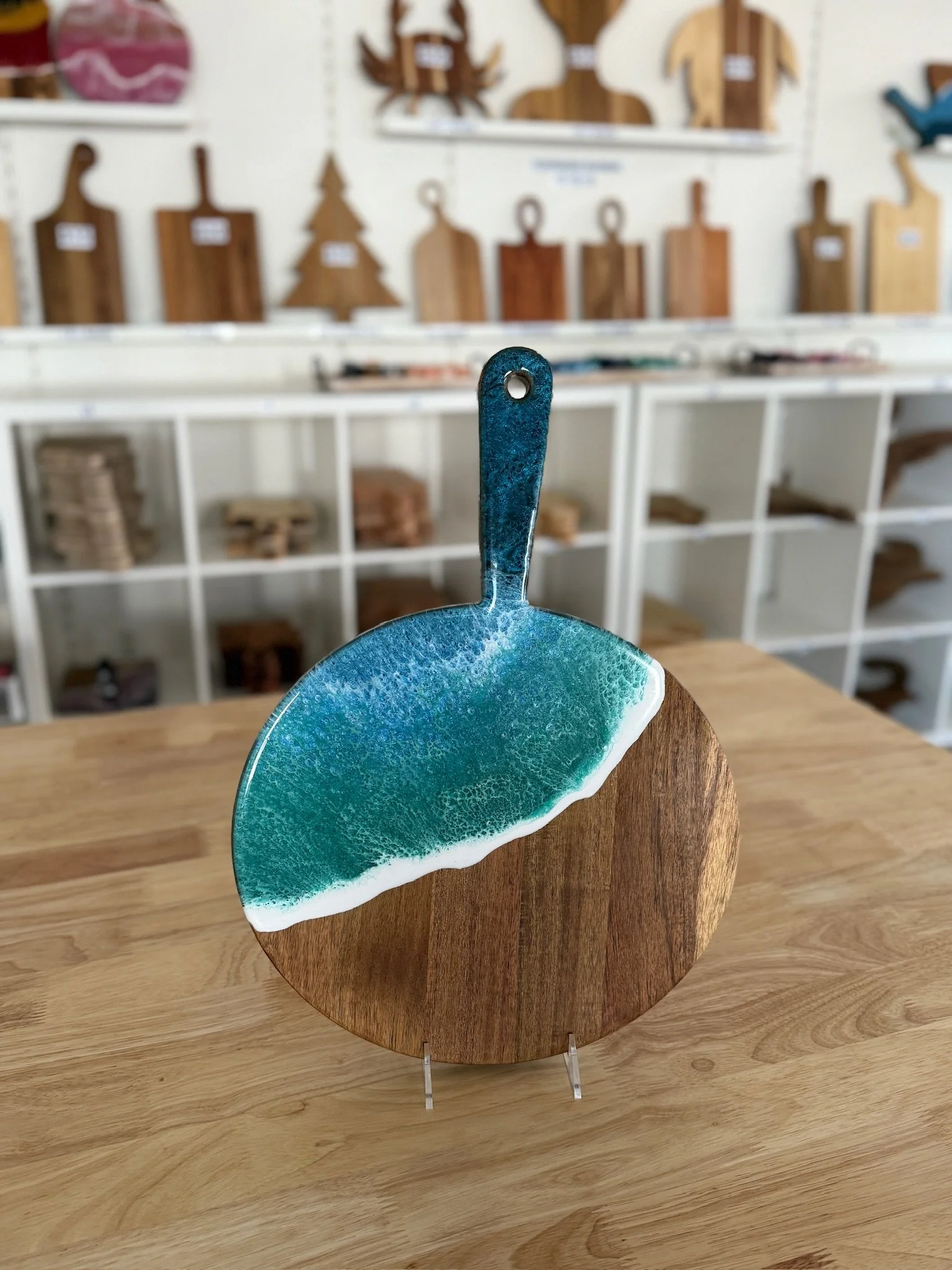 Round Wooden charcuterie board with resin ocean wave poured on it. 