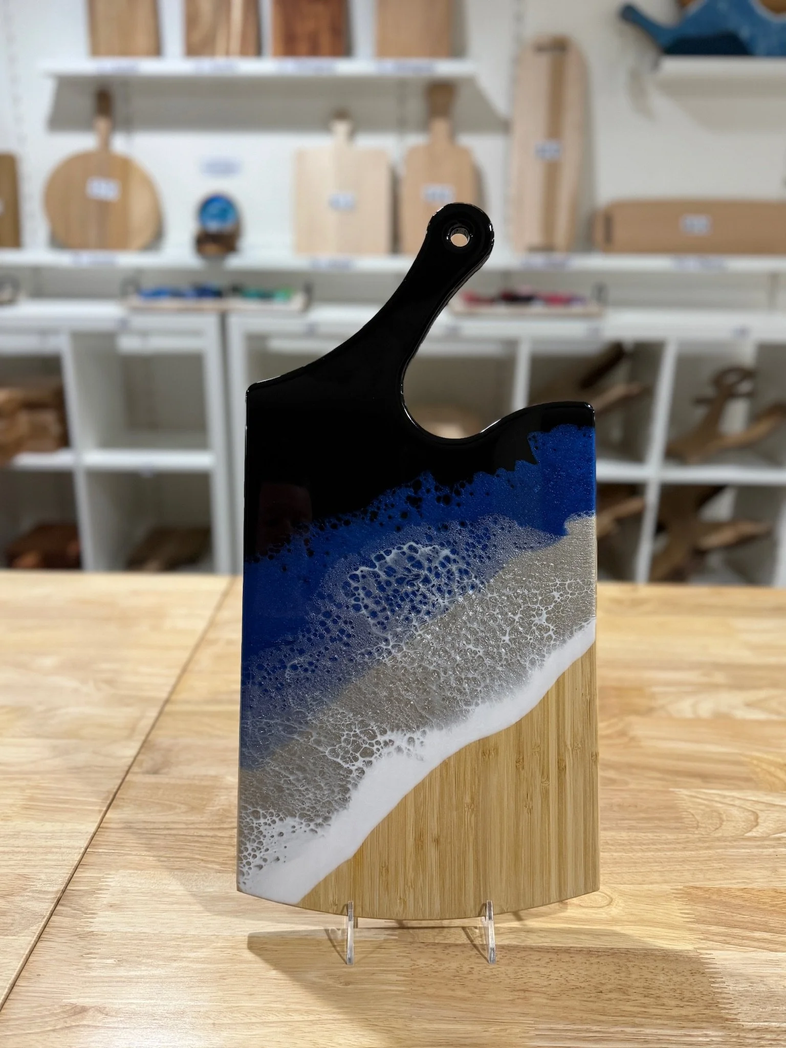 Large Wooden charcuterie board with resin ocean wave poured on it.