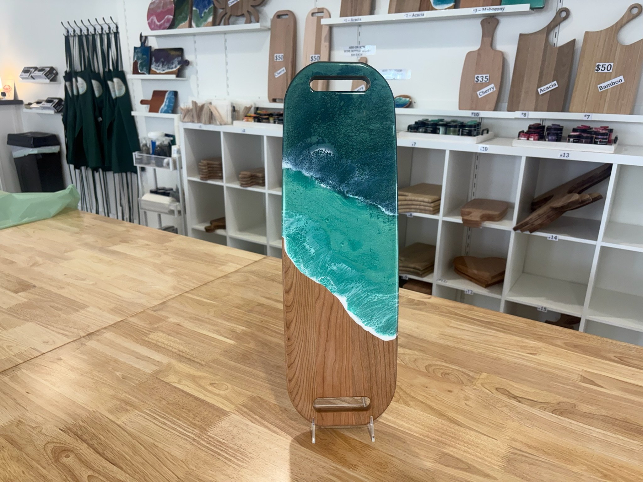 Large Wooden charcuterie board with resin ocean wave poured on it.