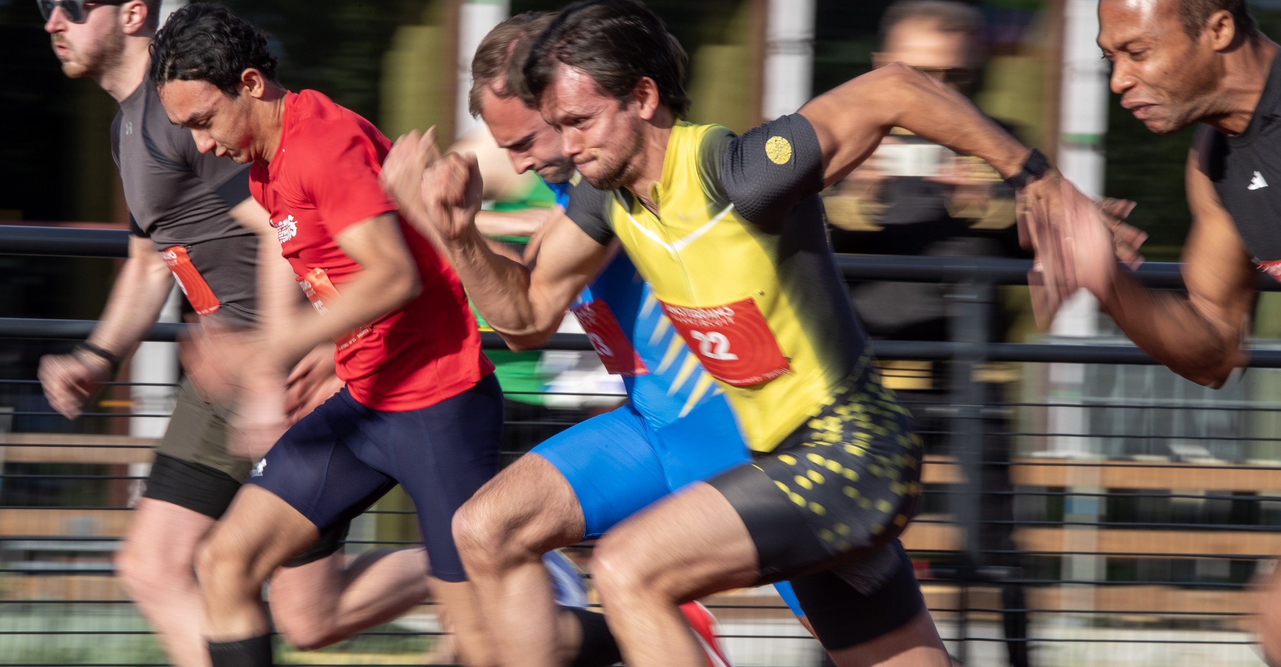 A group of runners competing in a race, captured in motion with blurred background.