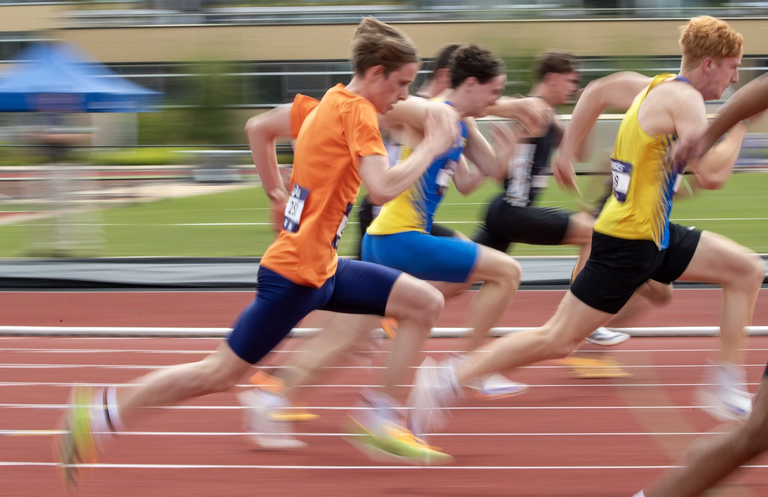 Young athletes running a race on a track during a sports event.