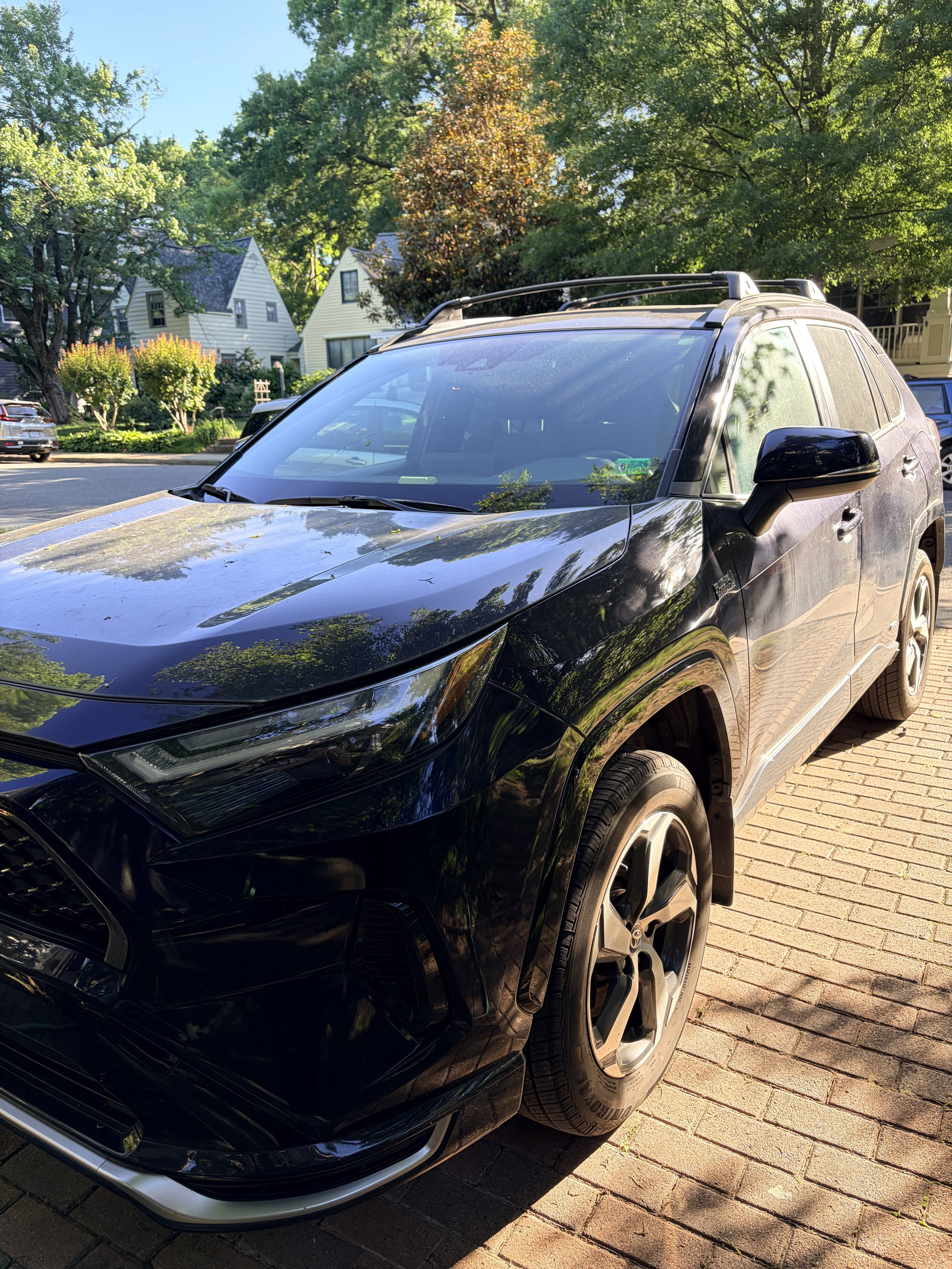 Black SUV covered in dirt and pollen before exterior detail in a driveway in Arlington VA