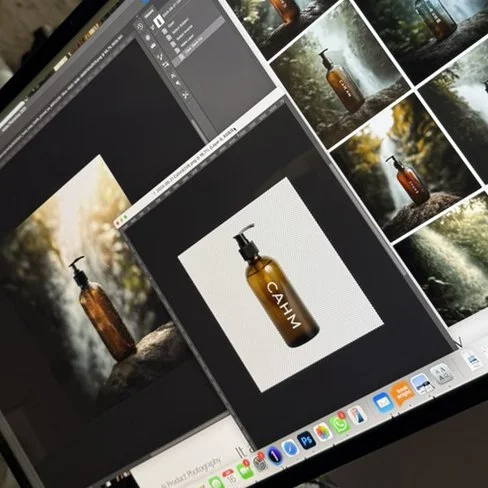 Computer screens displaying photos of a brown bottle with a pump dispenser labeled 'CASH,' surrounded by nature images and editing software.