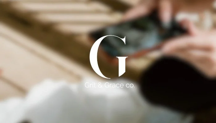 A blurred background of a person taking a photo with a cellphone, with the text 'Grit & Grace co.' in the center.