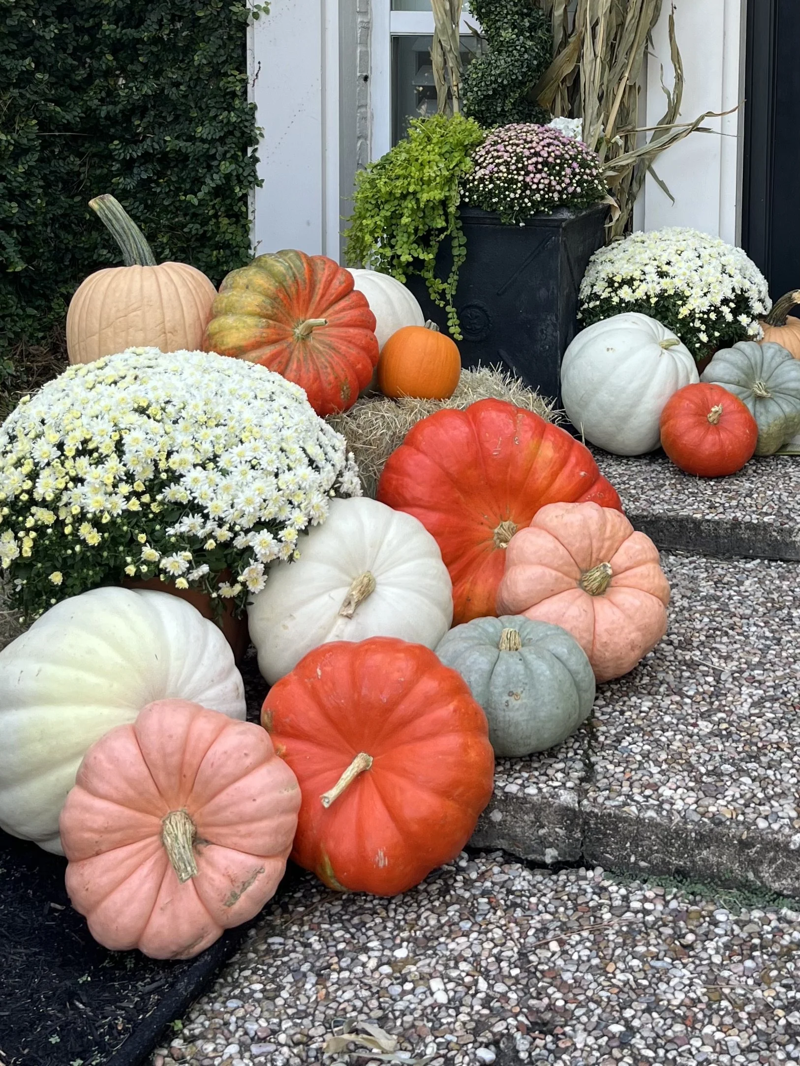Colorful pumpkins on a haystack make this porch looks perfect for fall.