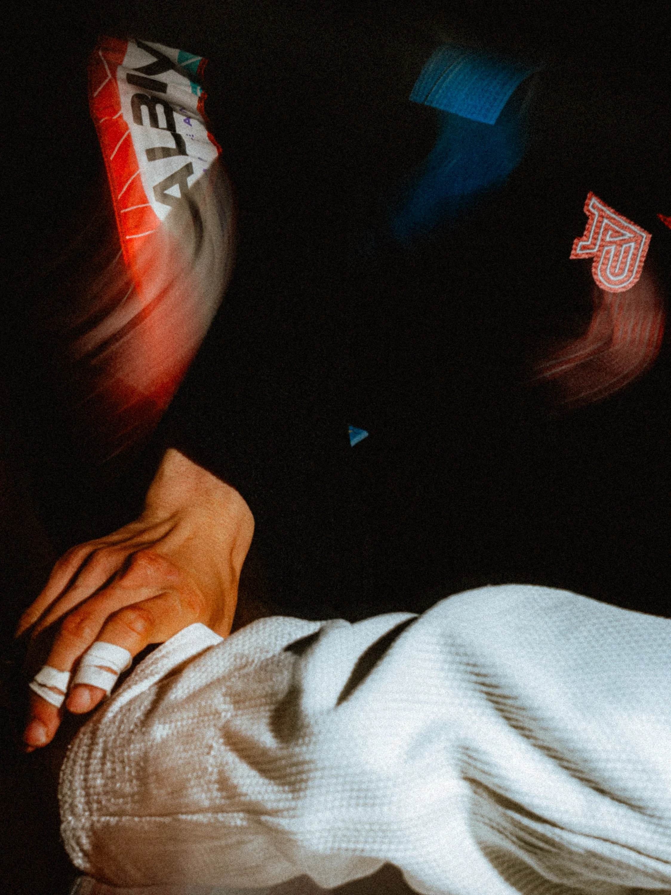 A person wearing a black shirt with logos and a white long sleeve shirt holding another person's hand with bandaged fingers. Personal Branding Photography and Headshots in London.