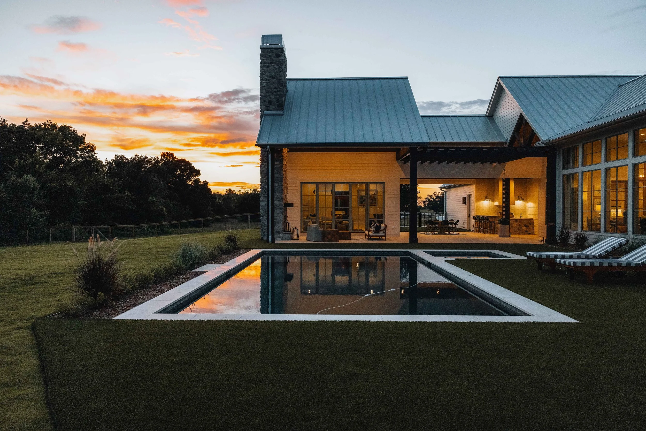 Skycrafted Imaging_Real Estate Media Production_Central & Southeast Texas_A modern house with a metal roof, large windows, and an outdoor patio area.