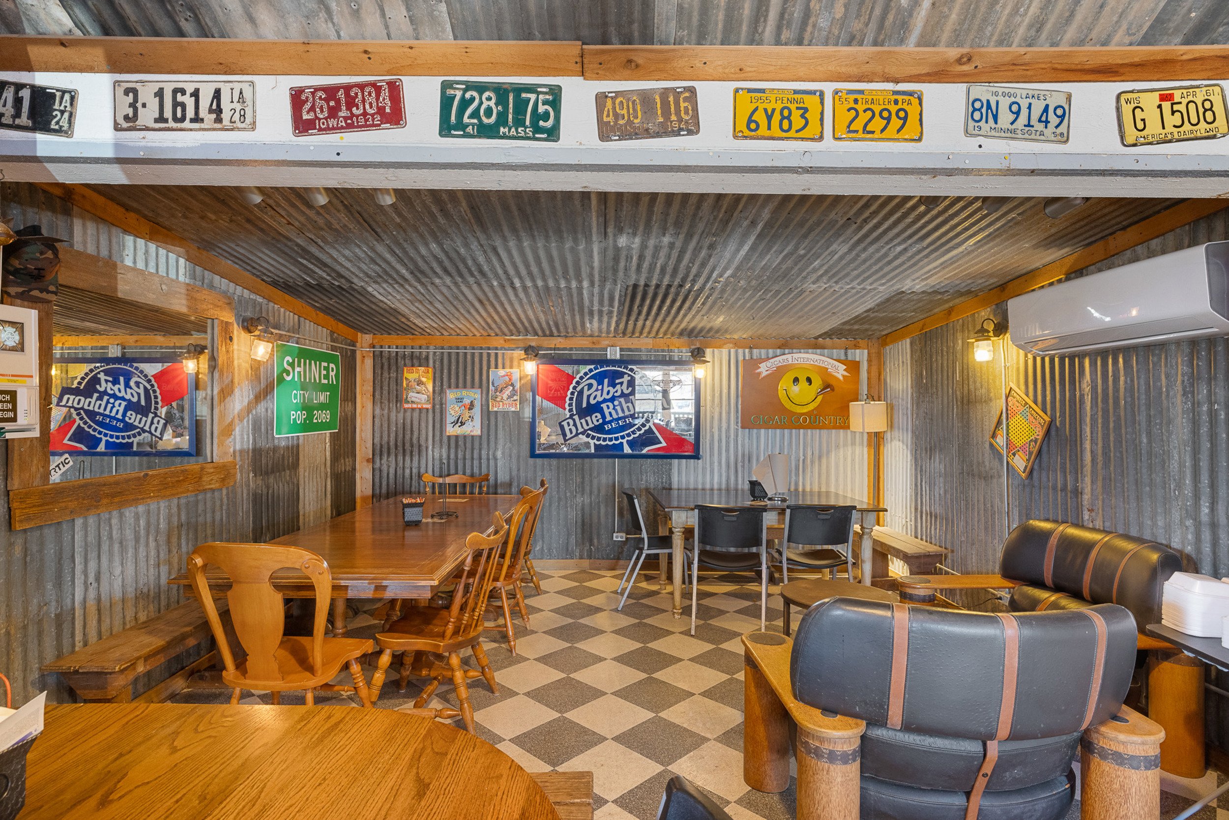 Skycrafted Imaging_Real Estate Media Production_Central & Southeast Texas_Interior of a rustic-style restaurant or cafe with metal walls and ceiling, featuring vintage license plates on the upper wall.