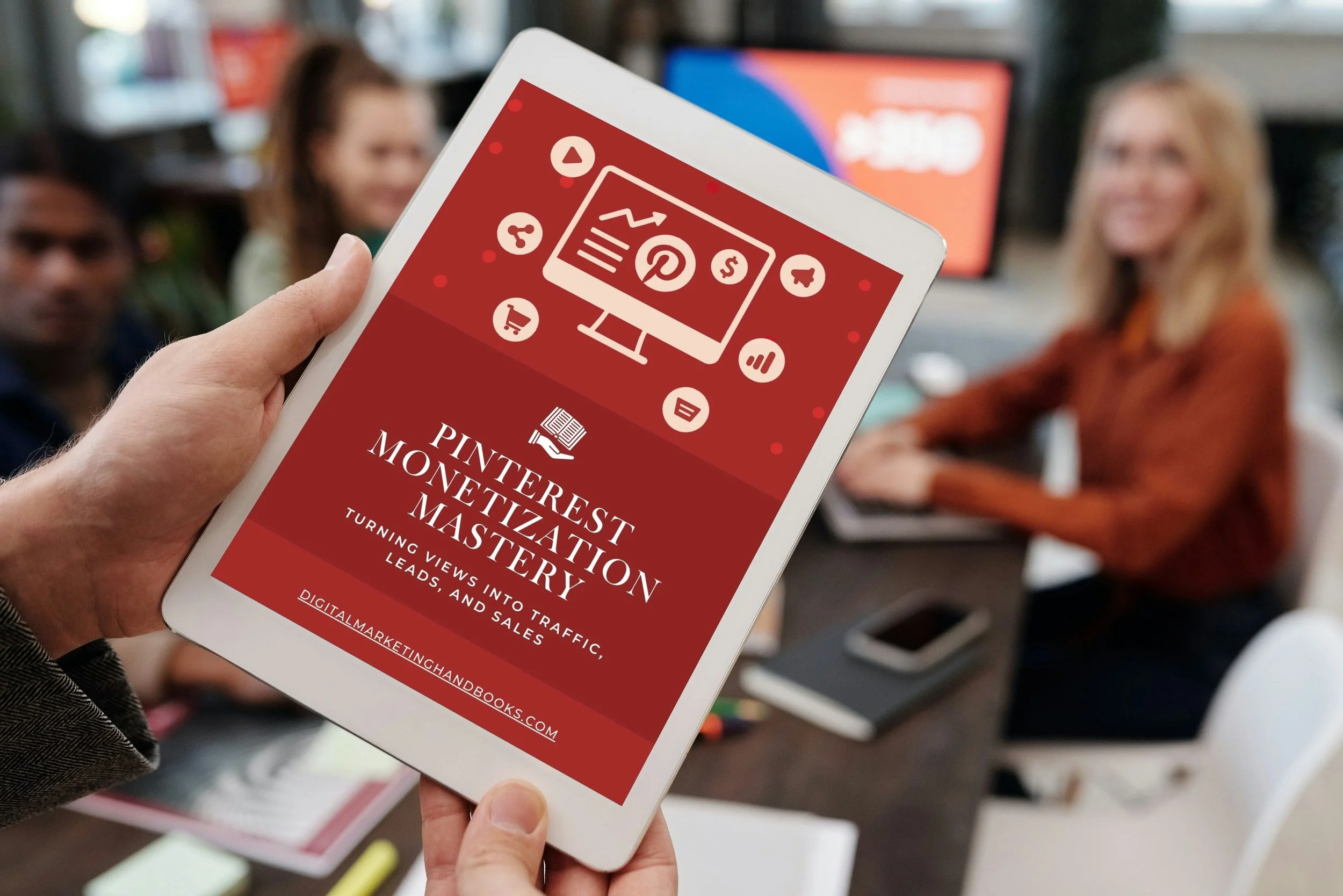 A person holding a tablet displaying a book cover titled "Pinterest Monetization Mastery" with a webinar theme, in a meeting room with three women around a table.