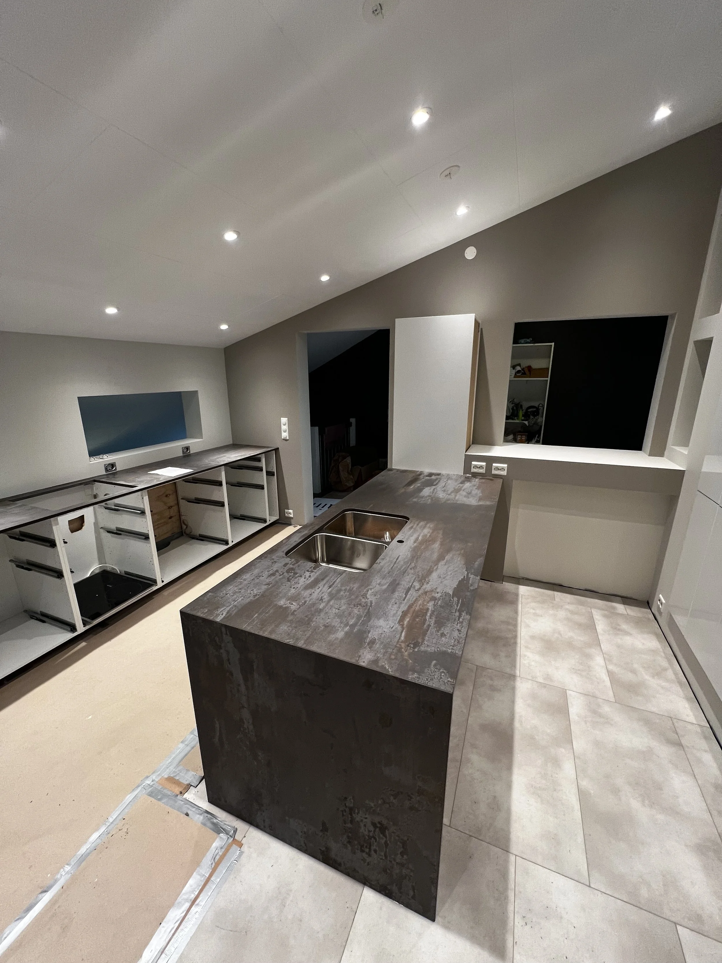 Moderne kjøkken med kjøkkenøy. Kjøkken fra IKEA. Gipsvegger og vinylgulv. Masse kjøkkenkabinetter. Under konstruksjon. 