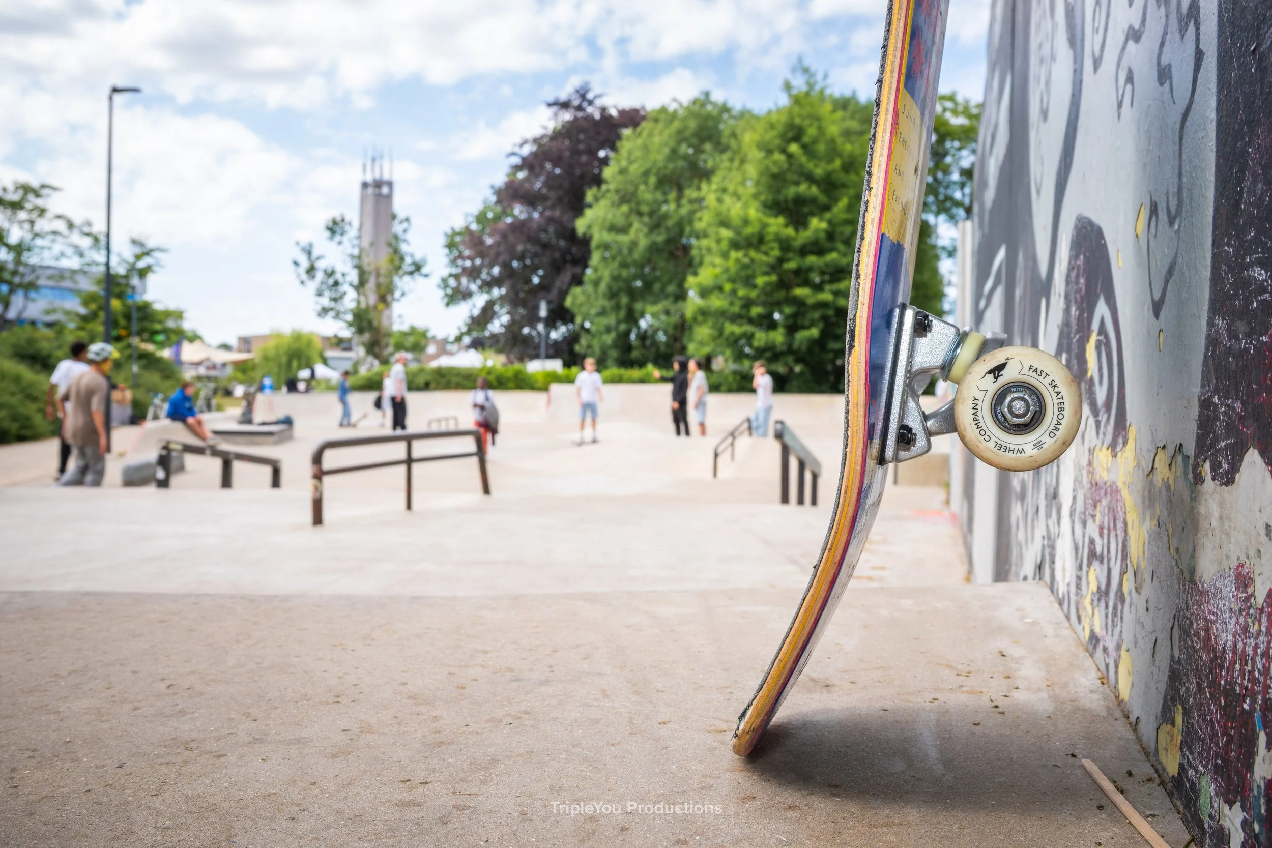 Een rechtstaand skateboard tegen een graffiti muur
