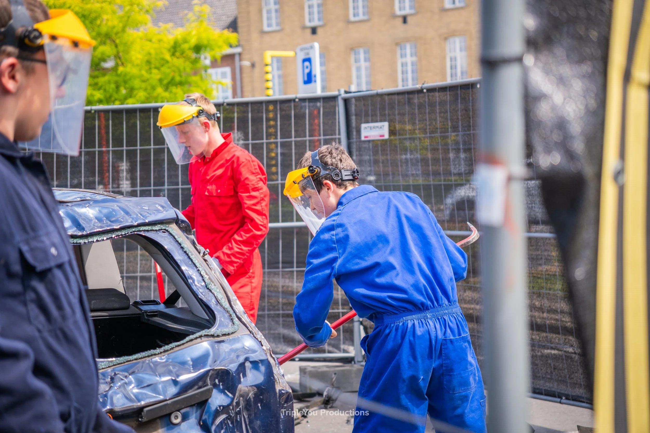 3 jongens met beschermende kledij, die zichzelf mogen uitleven op een autowrak. Ze doen mee aan een rageroom waarbij ze de auto volledig mogen kapot maken.