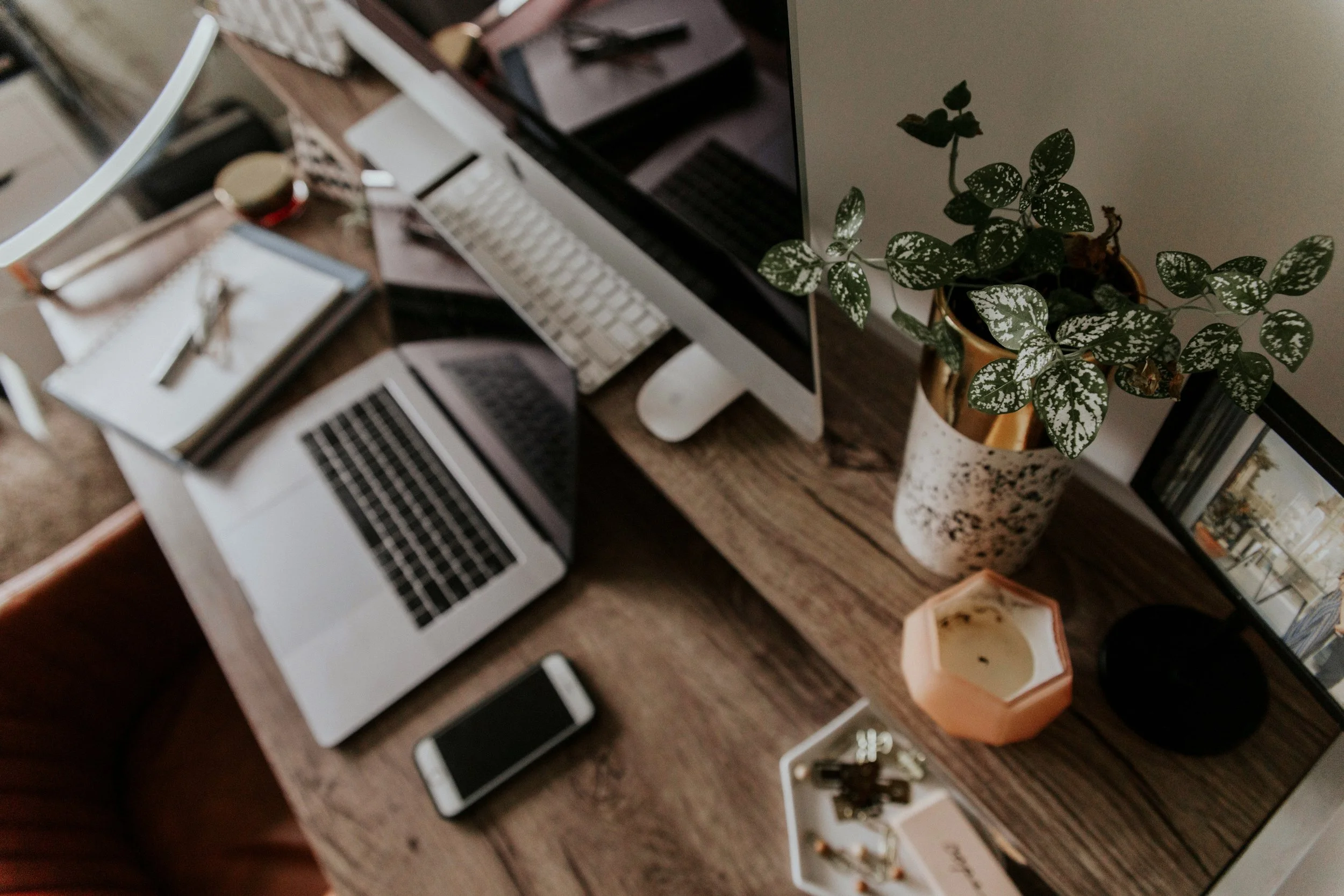 Desk with computer, notebook, candle, and plant