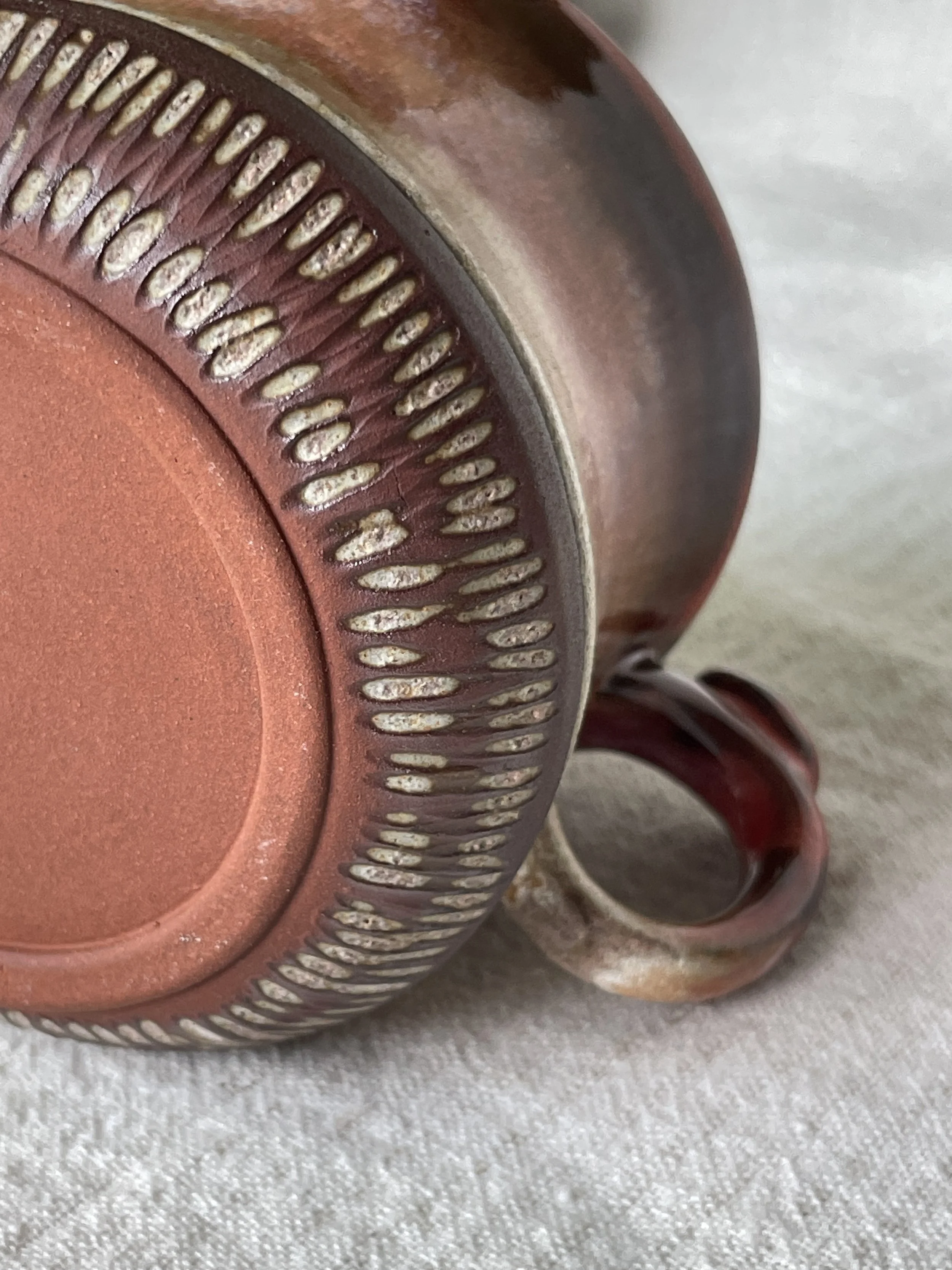 Detail view highlighting carved texture along the foot and underside.