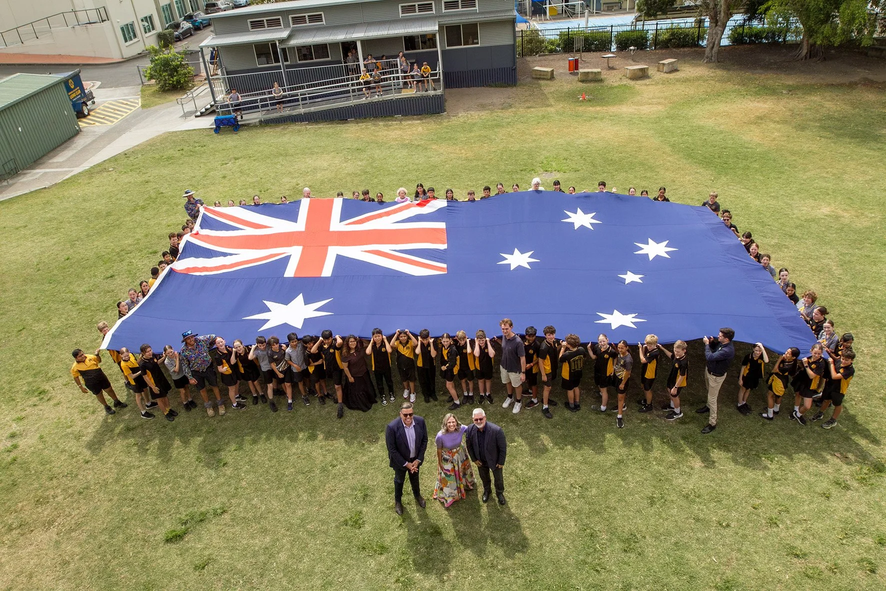 Children holding a large Australian flag.