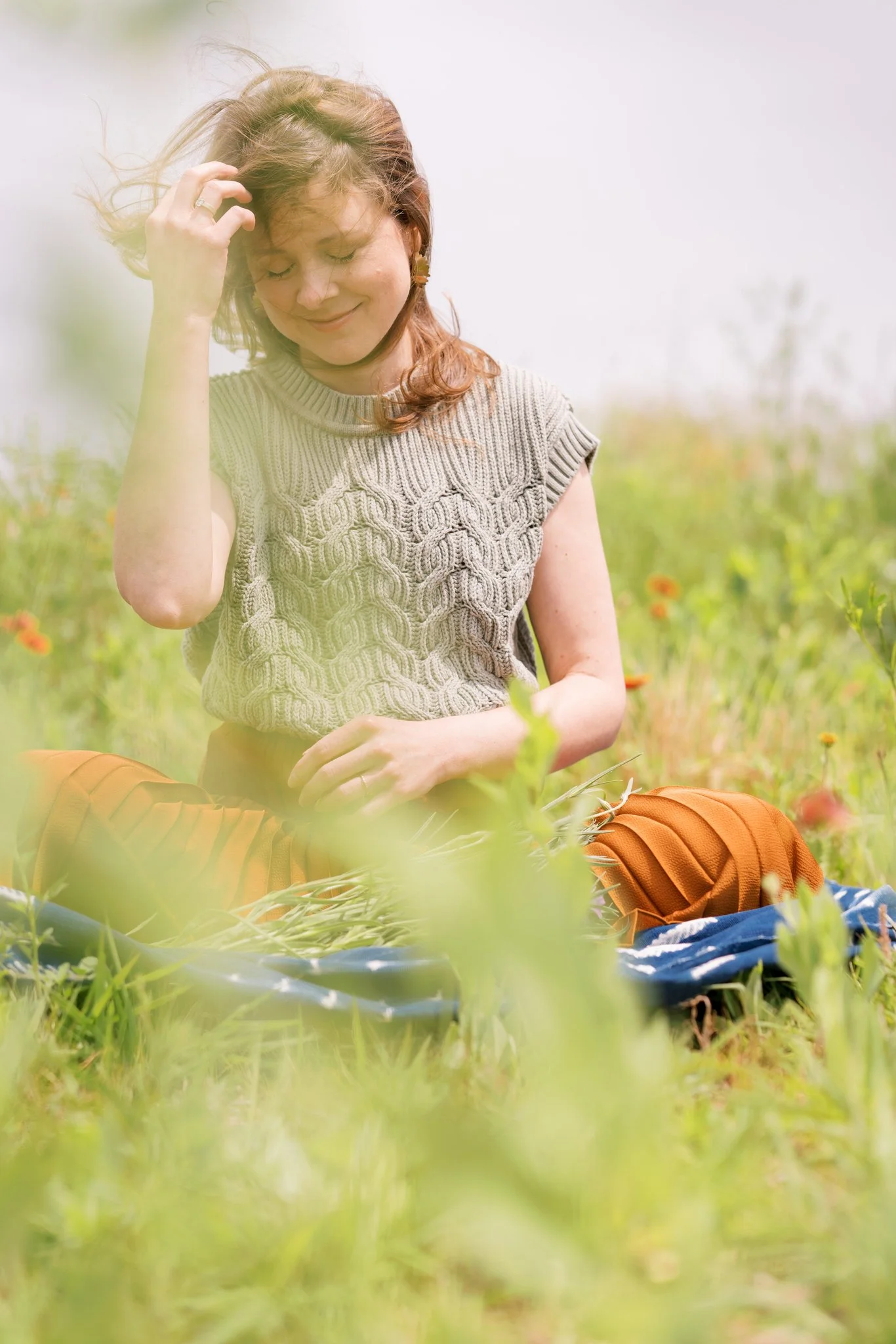 Tishna Rollo, LPC, seated among wildflowers.