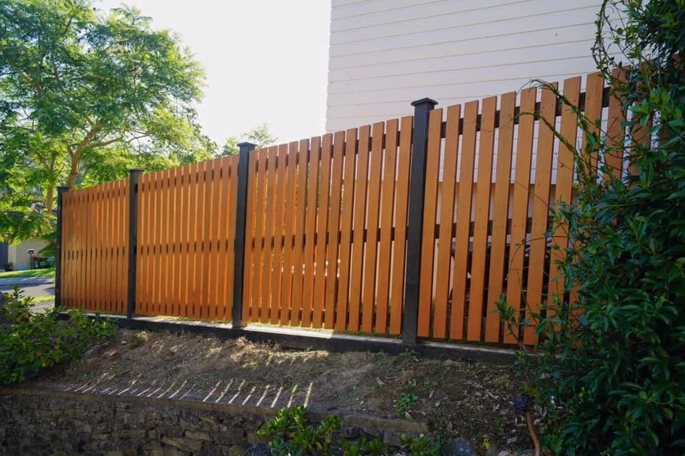 Modern vertical timber boundary fence with dark posts built by Capital G Construction and CGC Property Solutions in Tauranga