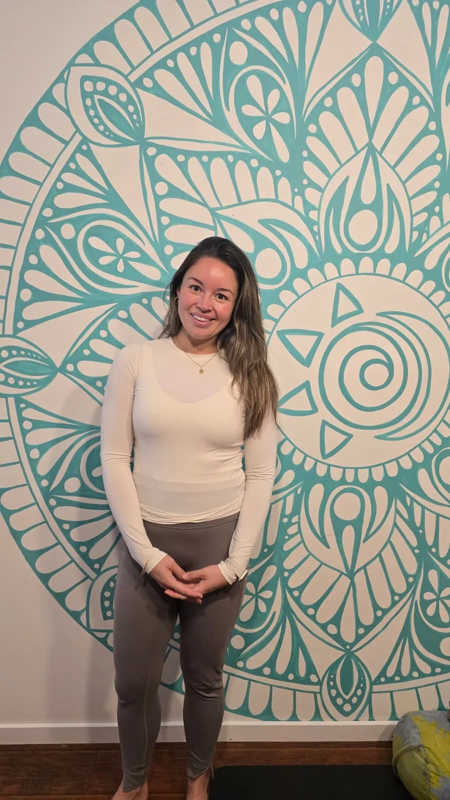 A woman doing a plank with one leg in the air in front of a mural wall