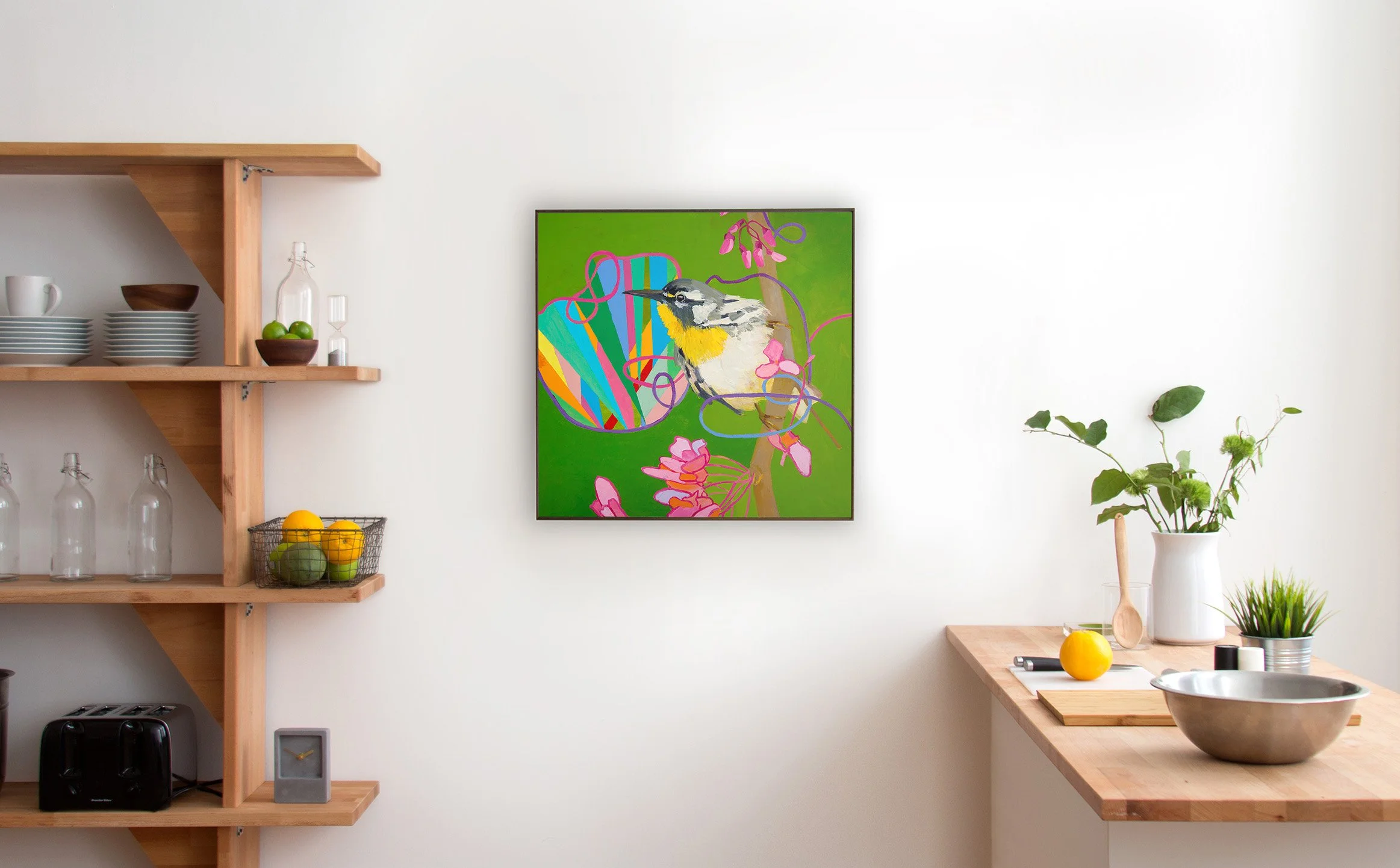 Minimalist kitchen with wooden shelves, glass bottles, and a colorful framed artwork of a bird on a green background.